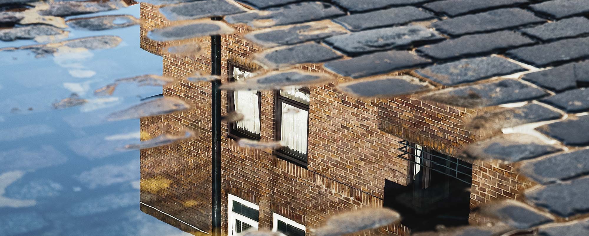 Housing Benefit Claim - Picture of a reflection of a home in a puddle